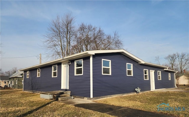 view of side of home with a yard