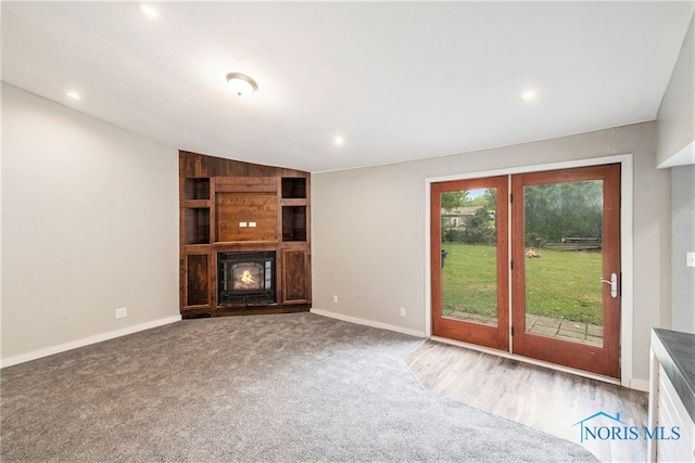 unfurnished living room featuring carpet and lofted ceiling