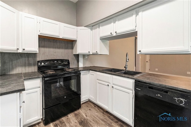 kitchen with white cabinets, black appliances, sink, and wood-type flooring