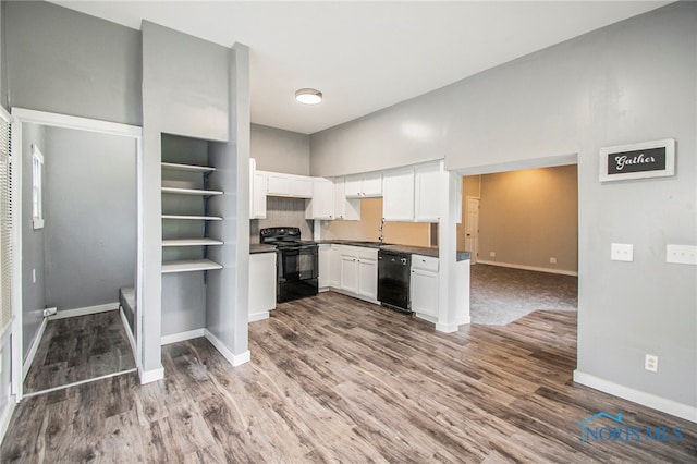 kitchen featuring white cabinets, hardwood / wood-style flooring, black appliances, and sink