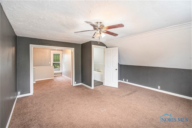 additional living space with a textured ceiling, carpet flooring, vaulted ceiling, and ceiling fan