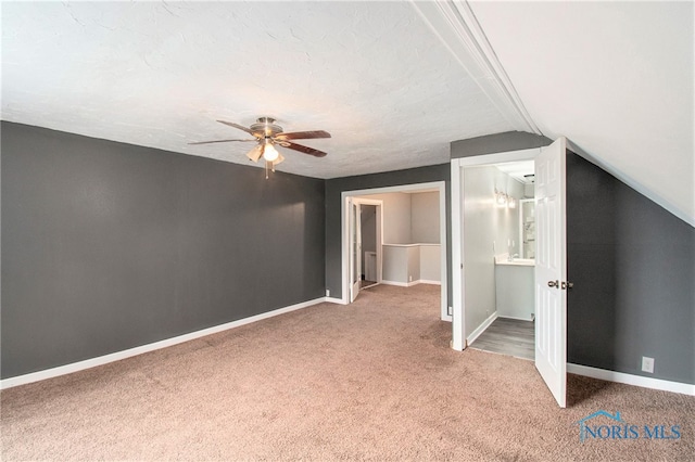 bonus room with a textured ceiling, vaulted ceiling, carpet flooring, and ceiling fan