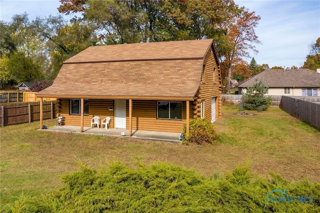 rear view of property featuring a yard