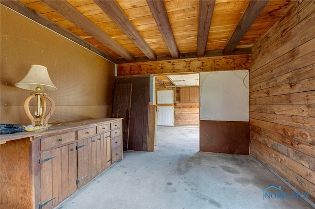 interior space with wood walls, beamed ceiling, and wooden ceiling