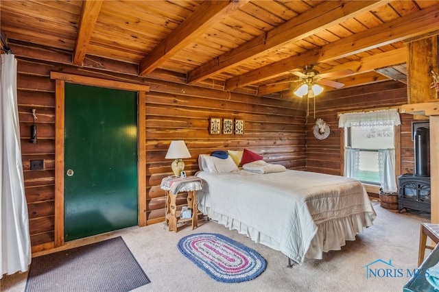 bedroom with wood ceiling, beamed ceiling, a wood stove, and ceiling fan