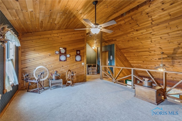 unfurnished room with vaulted ceiling, ceiling fan, and wood walls