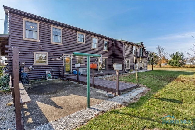 back of house featuring a patio, a deck, and a lawn