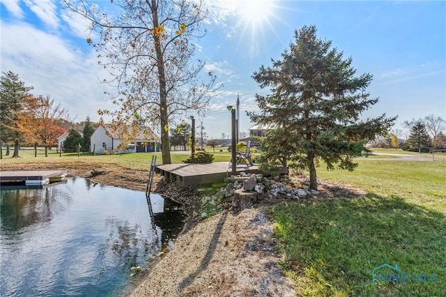 dock area featuring a water view and a lawn