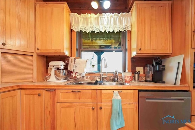 kitchen with a sink, stainless steel dishwasher, backsplash, and tile countertops