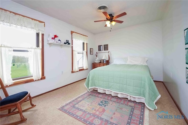 carpeted bedroom featuring ceiling fan, visible vents, and baseboards