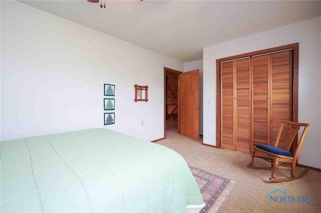 bedroom featuring a ceiling fan, a closet, and light colored carpet