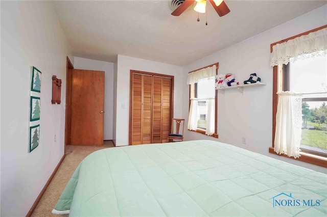 carpeted bedroom featuring a ceiling fan and a closet