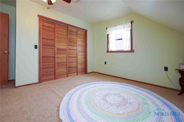 unfurnished bedroom with baseboards, ceiling fan, carpet, and a closet