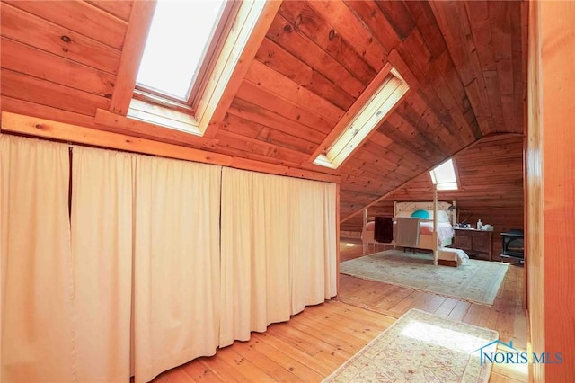 bonus room with vaulted ceiling with skylight, wooden ceiling, wood-type flooring, and wooden walls