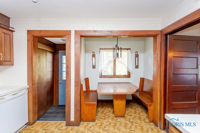 unfurnished dining area featuring brick wall and light parquet flooring