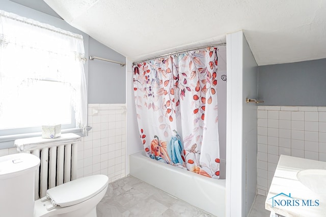 full bathroom with shower / bathtub combination with curtain, tile walls, vaulted ceiling, toilet, and vanity