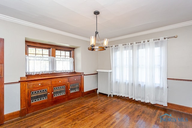 interior space with ornamental molding, dark wood-type flooring, a notable chandelier, and radiator heating unit