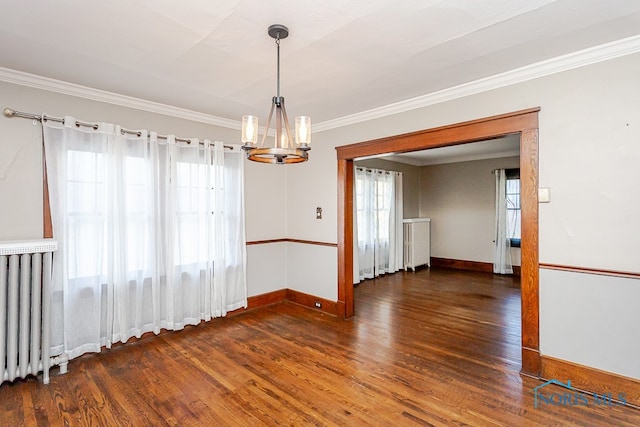 unfurnished dining area featuring ornamental molding, an inviting chandelier, dark wood-type flooring, and radiator