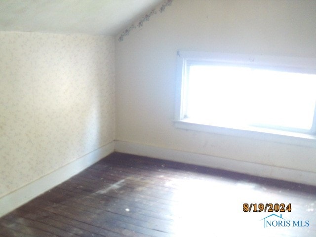 bonus room with dark hardwood / wood-style floors