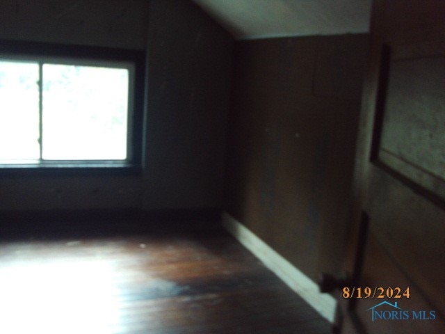 bonus room with hardwood / wood-style flooring and lofted ceiling