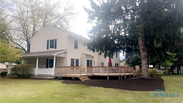 rear view of house with a deck and a yard