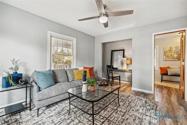 living room with hardwood / wood-style flooring and ceiling fan