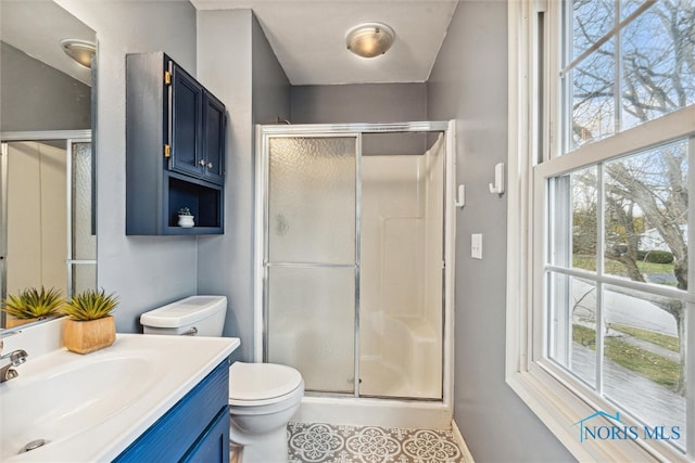 bathroom featuring toilet, vanity, an enclosed shower, and tile patterned flooring