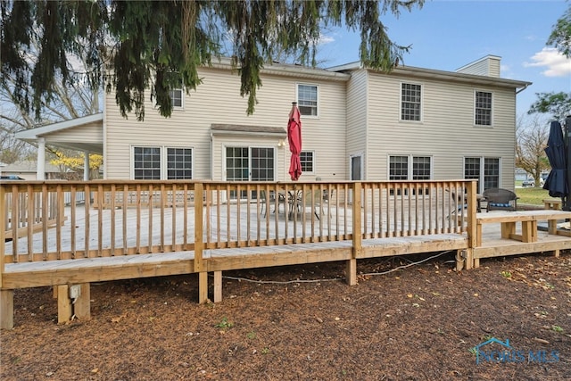 rear view of house featuring a wooden deck