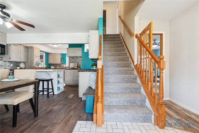 stairway featuring wood-type flooring and ceiling fan