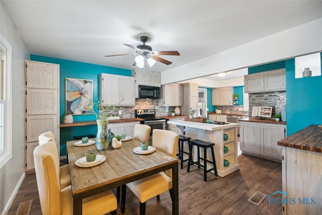 dining area with dark wood-type flooring and ceiling fan