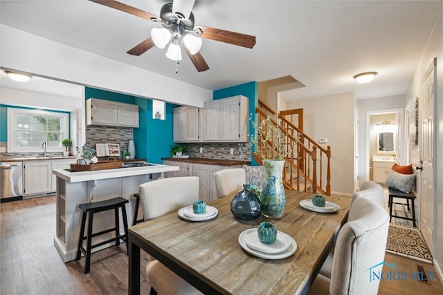 dining room with hardwood / wood-style flooring, ceiling fan, and sink