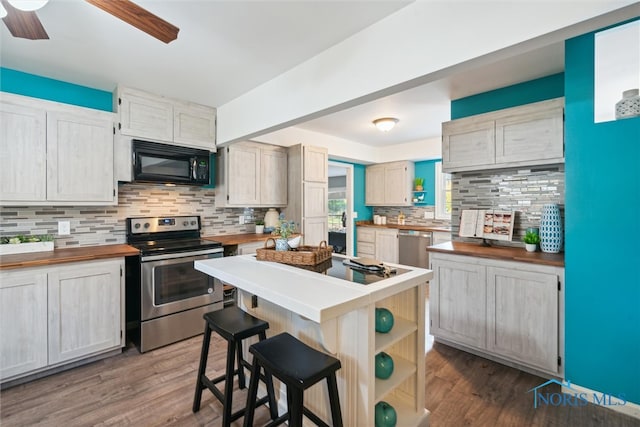 kitchen featuring decorative backsplash, appliances with stainless steel finishes, and dark hardwood / wood-style floors