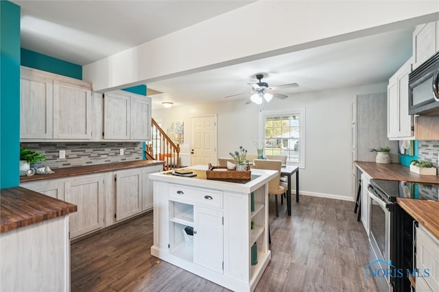 kitchen featuring stainless steel appliances, backsplash, a center island, butcher block countertops, and dark hardwood / wood-style flooring