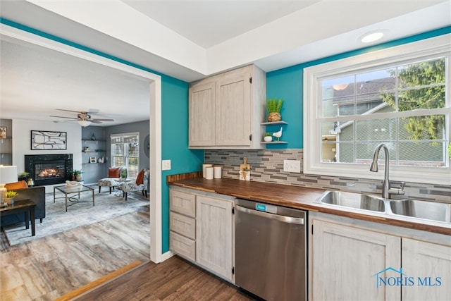 kitchen featuring sink, tasteful backsplash, dark wood-type flooring, wood counters, and dishwasher