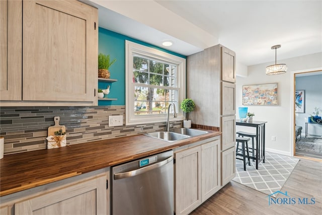 kitchen with light hardwood / wood-style floors, sink, light brown cabinets, hanging light fixtures, and dishwasher