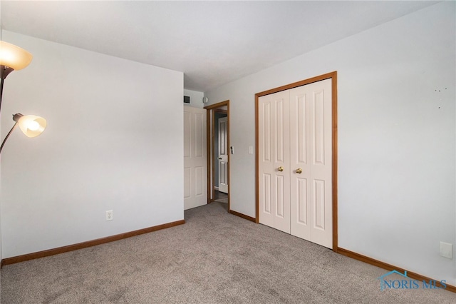 unfurnished bedroom with light colored carpet and a closet