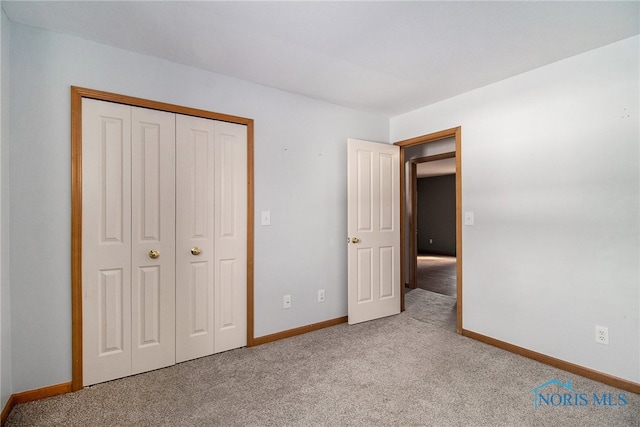 unfurnished bedroom featuring light colored carpet and a closet