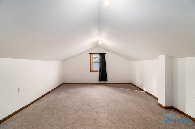 additional living space featuring carpet flooring and lofted ceiling