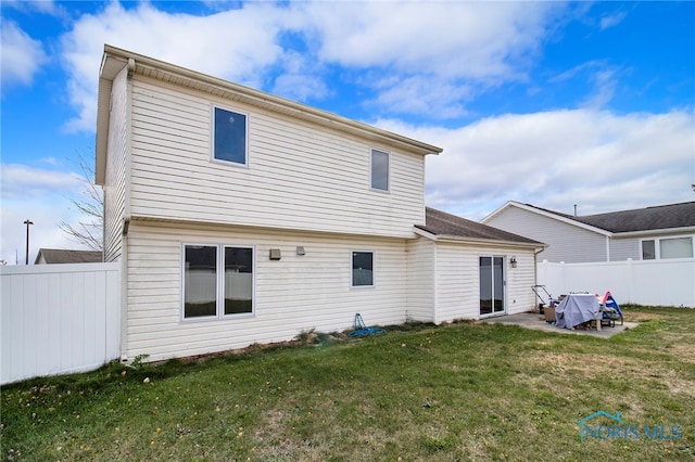 back of house featuring a patio and a lawn