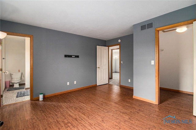 bedroom featuring hardwood / wood-style flooring and ensuite bath