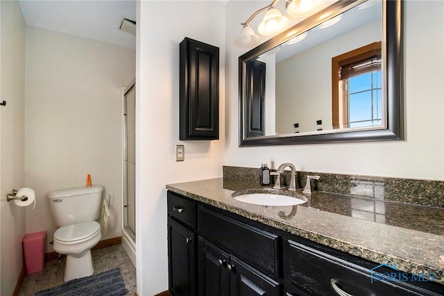 bathroom with toilet, vanity, and a shower with door