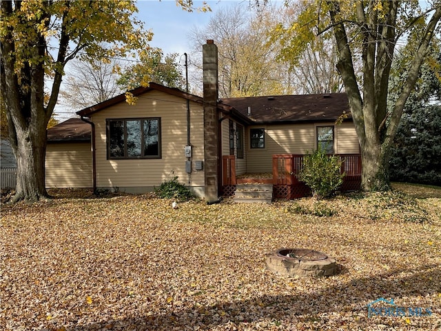 exterior space with an outdoor fire pit and a deck