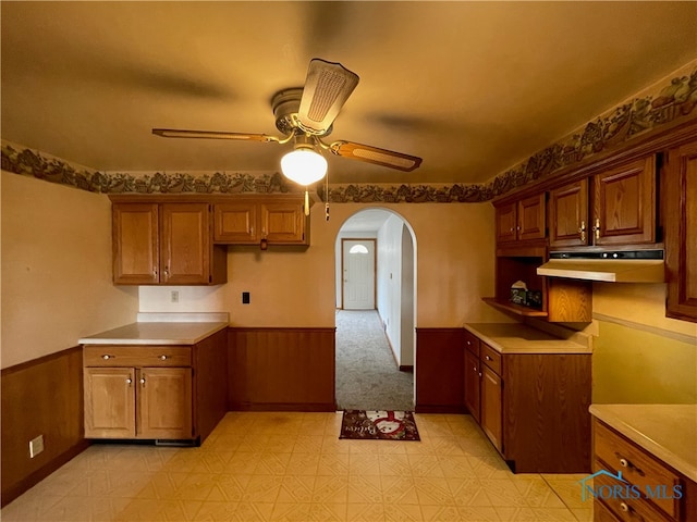 kitchen with ceiling fan and wood walls