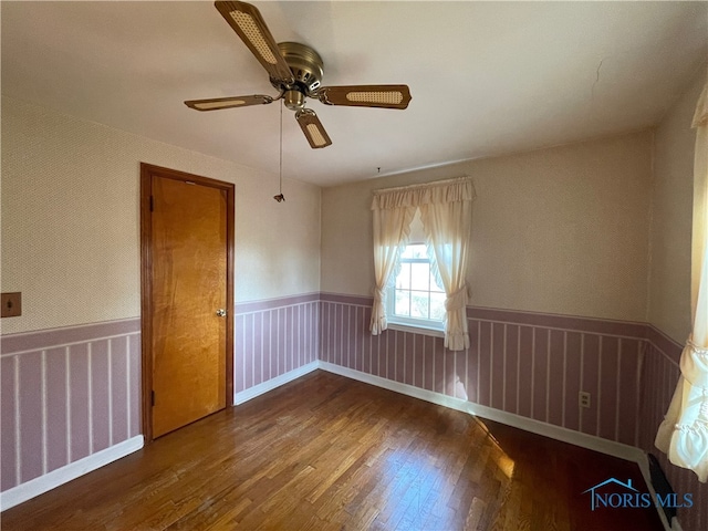 unfurnished room featuring ceiling fan and dark hardwood / wood-style flooring