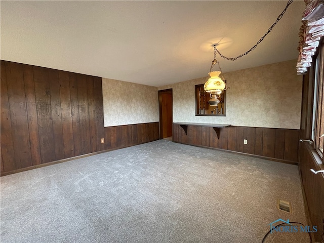 spare room with wooden walls and light colored carpet