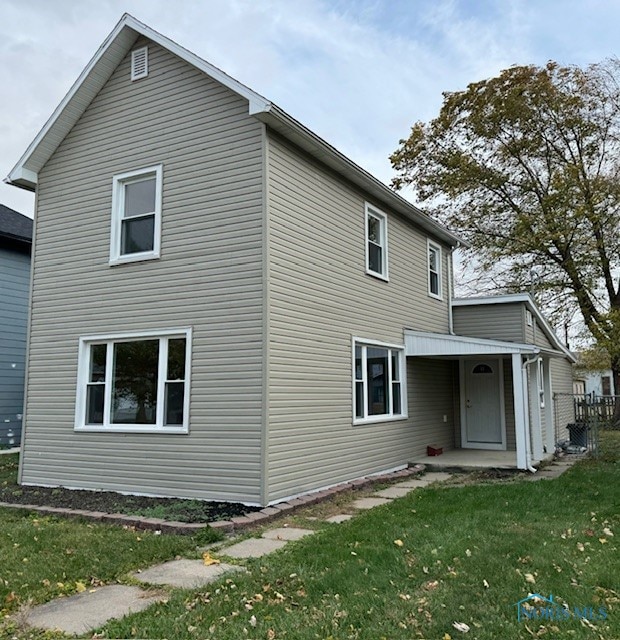 back of house featuring a lawn