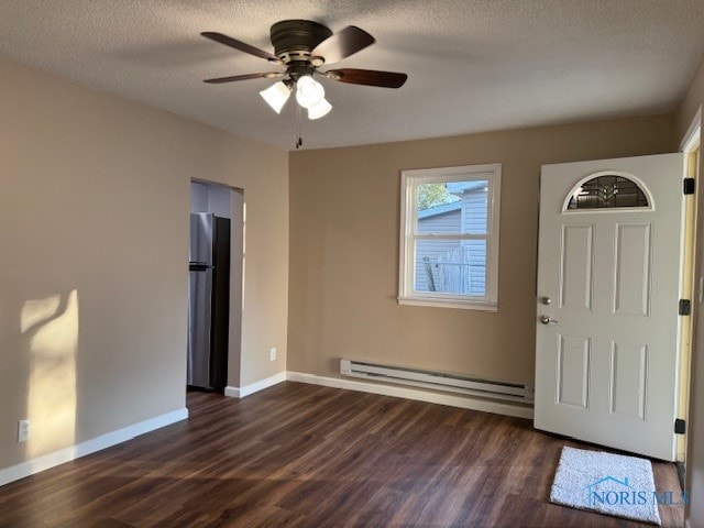 entryway with ceiling fan, a textured ceiling, baseboard heating, and dark hardwood / wood-style floors