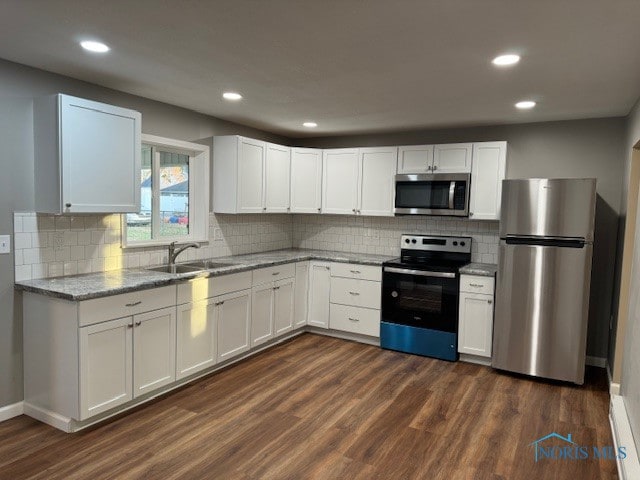 kitchen featuring light stone countertops, sink, appliances with stainless steel finishes, dark hardwood / wood-style flooring, and white cabinets