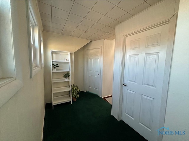 hall with dark colored carpet