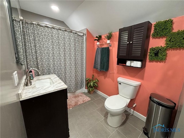 bathroom featuring lofted ceiling, vanity, tile patterned flooring, toilet, and curtained shower